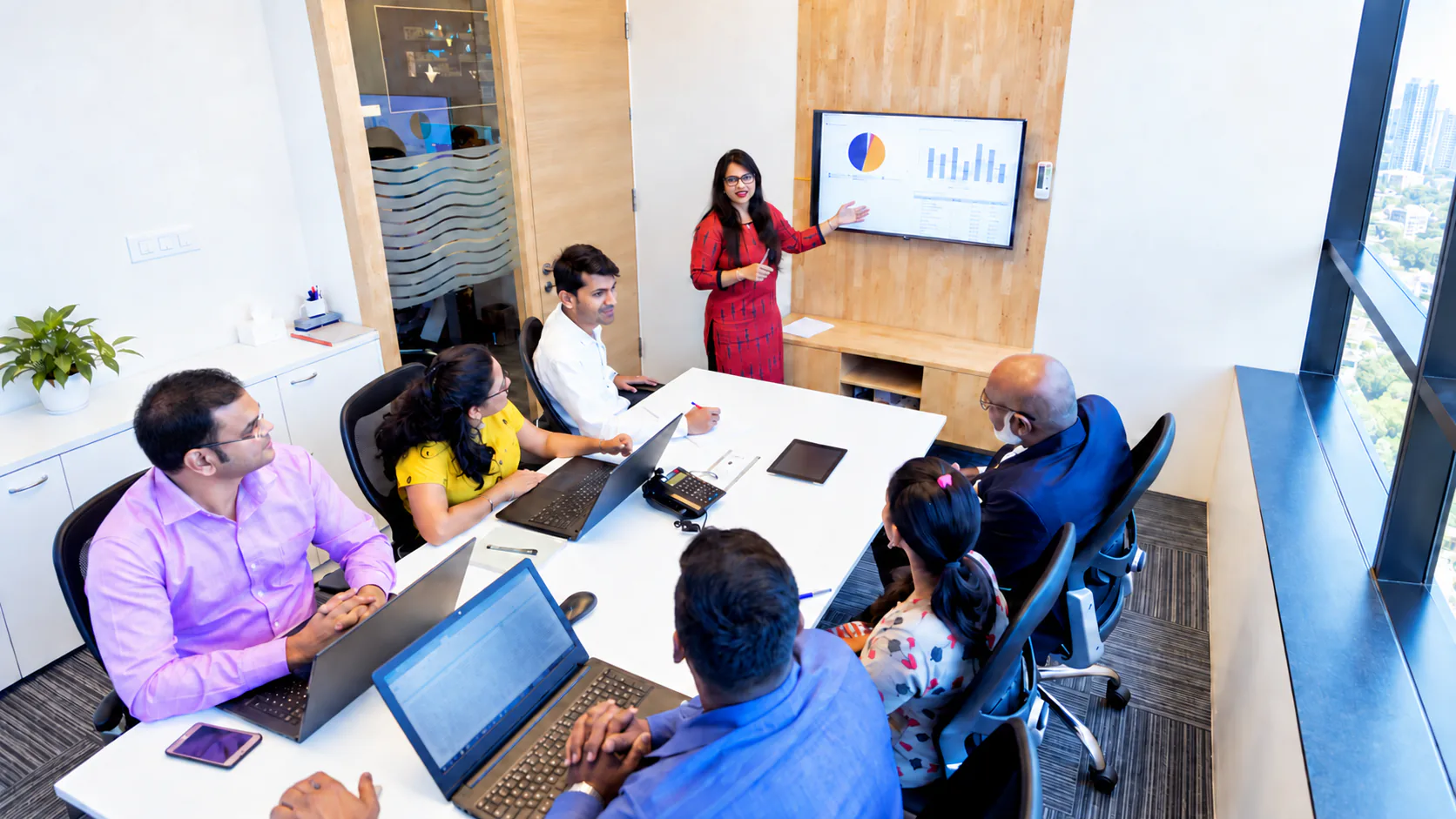 A business team in a meeting while a colleague presents
